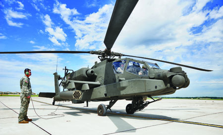 U.S Army Sgt. Keno Davidson of the 135th, AH-64D Apache Longbow crew chief, performs pre-flight checks on an Army AH-64D Apache Longbow. (Photo courtesy of Whiteman AFB)