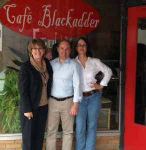  (Courtesy photo) From left, City Manager Paula Hertwig Hopkins, Main Street President Jason Elkins, and Café Blackadder owner Sandy Irle pose in front of the café after the announcement about the business being awarded the first downtown façade grant.