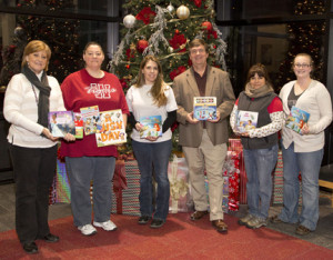 Mary Clevenger, left, outreach coordinator for KMOS-TV, and Mark Pearce, third from right, coordinator of corporate and community support, presented children’s books to Johnson County Community Christmas Angel Tree volunteers, from left, Jennifer Hardin, Wendy Wood, Valentina Kelleher and Cassie Williams.