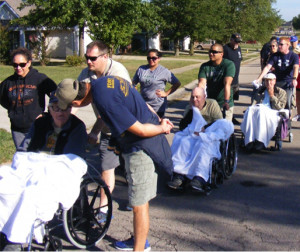 Veterans and their volunteers file along Foxrun Drive in Warrensburg to draw a playing card for the poker game on the Run for Freedom 5K course. Participants picked cards from decks set up across the course and the best hand was revealed after the walk.