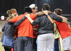 PHOTO BY LIZZIE RIDDER / PHOTOGRAPHER THRIVE students huddle around each other to commemorate another night of softball at the South Recreation Complex Tuesday night.
