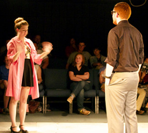 From left, Sarah Bronson as young woman and Caleb Gazaway as young man, stand far from each other Friday night in the Black Box Theatre, wondering where their first date is going to lead them as part of the “Coax” play for the Studio One-Act series.