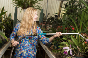 PHOTO BY BRANDON BOWMAN / PHOTO EDITOR Emily Dunlap waters the plants Tuesday in one of the university-owned greenhouses on Broad Street.