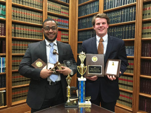 PHOTO BY DENISE ELAM / REPORTER The advancing mock trial team co-captains Broderick Hayes (left) and David Rogers hold the awards they have won individually and as a team during the 2015-2016 mock trial season.
