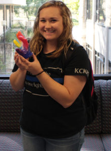 PHOTO BY MYLES VANN/PHOTOGRAPHER Sophomore Carly Hall poses with her wax hand mold of her sorority Sigma Kappa's hand sign.