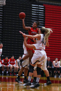 PHOTO BY ALEX PHILIPPS/PHOTOGRAPHER Kayonna Lee jumps over three Minot State defenders during the Jens first win of the season Saturday, Nov. 12, at the Multipurpose Building. Lee ended the game with 10 points and two assists.